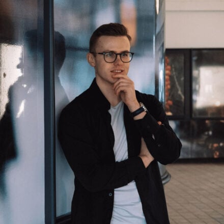Germans Frolovs standing thoughtfully against a reflective glass wall